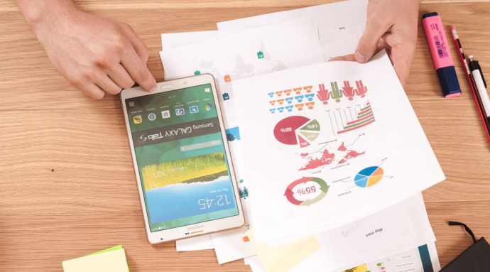 An image of a mobile phone along with some stationery products on the table